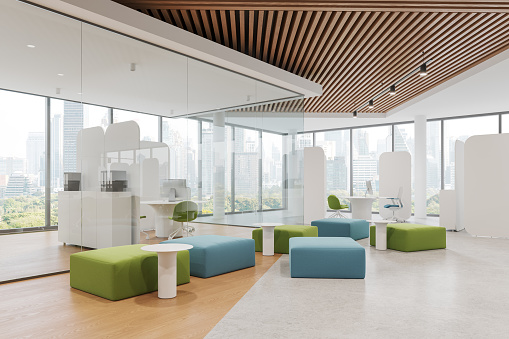 Stylish office interior with coworking and chill corner, divider and glass partition. Side view pc computers on desk and modular sofa. Panoramic window on Bangkok skyscrapers. 3D rendering