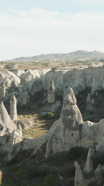 Vertical video. A panoramic view from a high mountain overlooking Love Valley and the rock formations in the shape of Fairy Chimneys.
