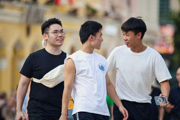 Macao, China - May 12, 2023: A group of young men stand next to each other on a street in Macao.