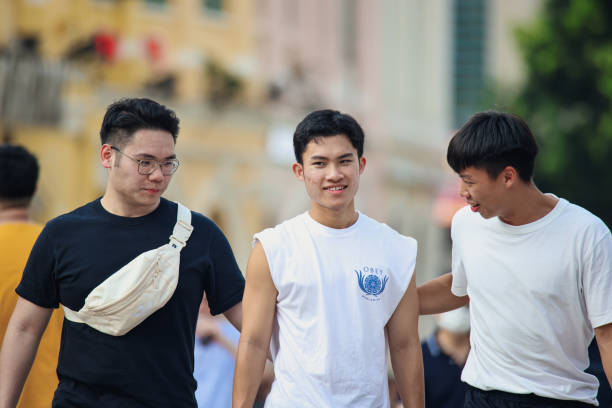 Macao, China - May 12, 2023: A group of young men are seen standing next to each other on a street in Macao.