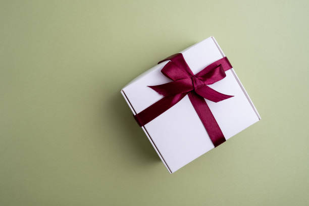 istock Gift box with a bow on a colored background. Happy Holidays, gift box close-up. Boxing Day surprise. Magic time. Wrapping paper, toys and ribbon 1985758973