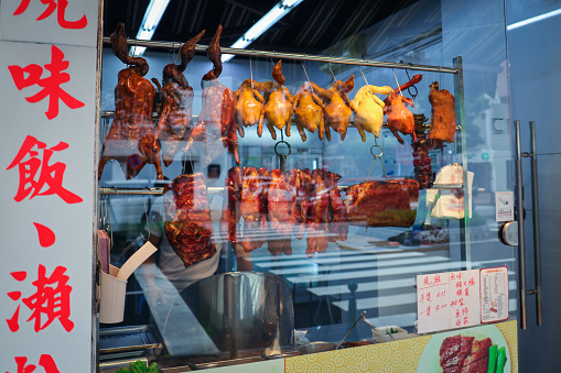 A variety of raw meat is displayed in an abundant assortment, hanging in a store window in Macao.