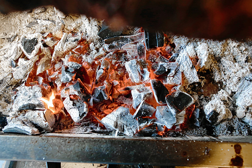 A close-up photo of a barbecue grill with various types of food cooking on the grates.
