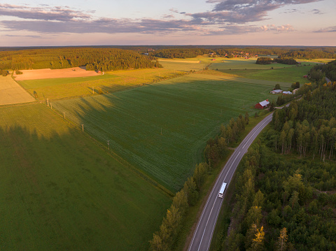 Aerial view of a bus on route in a rural landscape in the Sauvo municipality in southern Finland in summer.