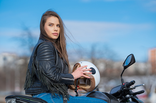Female motorcyclist going on a road trip, traveling on a motorbike