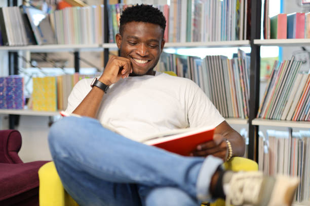 istock A happy and focused student in a university library, surrounded by books, engaged in academic pursuits. 1985779872