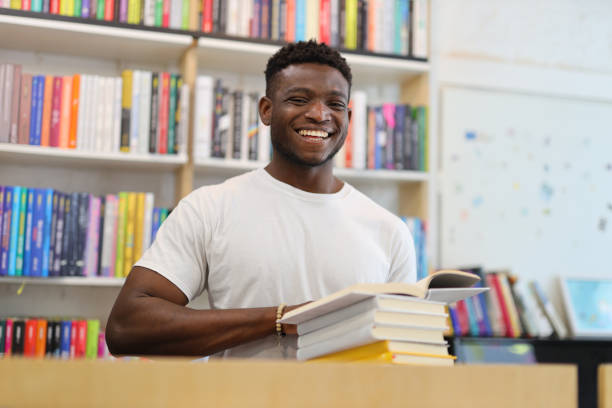istock A cheerful young student in a library, surrounded by books, embodying a modern and academic lifestyle. 1985779883
