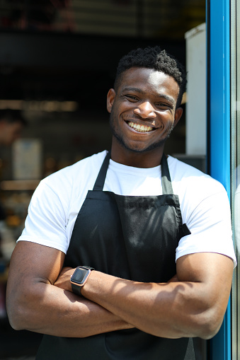 Confident and happy African American entrepreneur in a restaurant, exuding professionalism and culinary expertise.