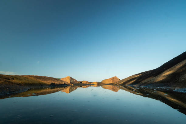 istock Mirrored rocks on the water 1985783991