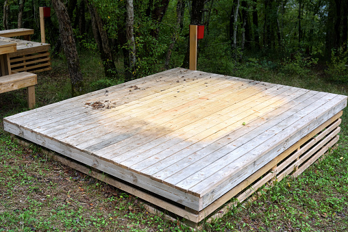 Wooden flooring made of boards for setting up a tent in the forest. Outdoor tourism.