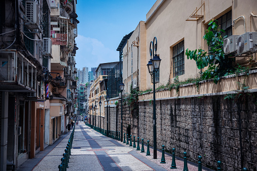 Macao, China - May 12, 2023: A bustling street in Macau, featuring a narrow space surrounded by towering buildings.
