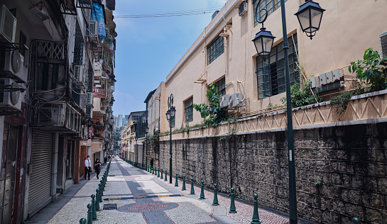 Macao, China - May 12, 2023: An image of an empty street in Macau with a small number of people walking down it.