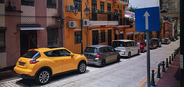 Macao, China - May 12, 2023: Several cars parked on the side of a street in Macau, creating a busy and bustling scene.