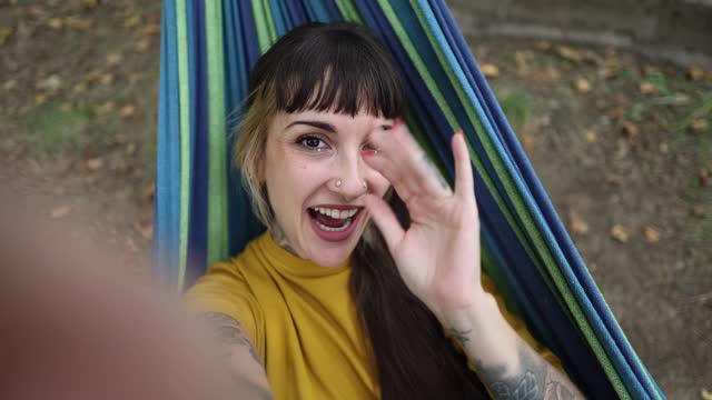 close up portrait of woman making video call on a hammock