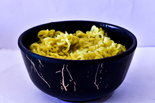 Noodles in a bowl in a white background.
