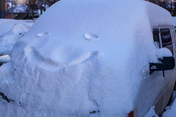 istock Parked minibus is completely covered in deep snow with a smiley face on it. 1985884794