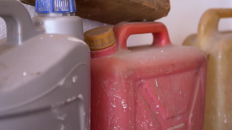 A Lots Old Dirty Colorful Plastic Canisters of Fuel Stand in the Garage. 4K