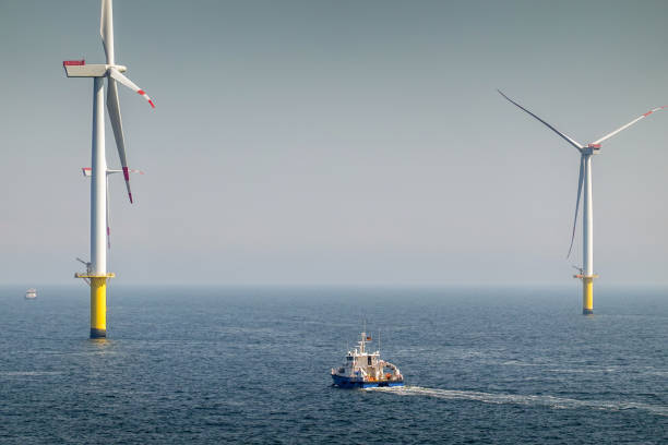 istock Epic Sunrise over Offshore Wind farm and substation on the horizont, vessel between them, bright sky, Borkum Riffgrund Germany 1985943315