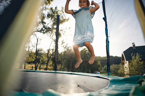 Beautiful girl enjoying summer days on trampoline.