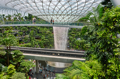 Singapore, Singapore - September 03, 2023: visitors tours the Rain Vortex, an artificial waterfall at Jewel Changi Airport. Singapore.