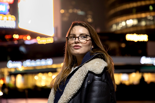 Beautiful woman in city lights at night