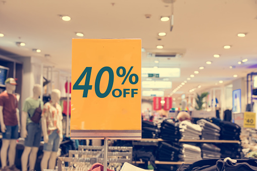 sign showing discount in clothes store