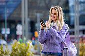 Digital Joy: Solo Traveler Smiles While Texting in the City