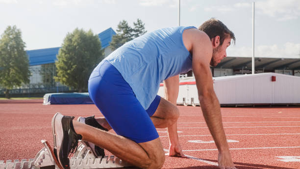 istock Male athlete taking a start position for a sprint run 1986040364