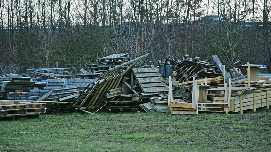 Messy Heap of Wooden Waste from Transport Pallets and Crates Stored Outdoors