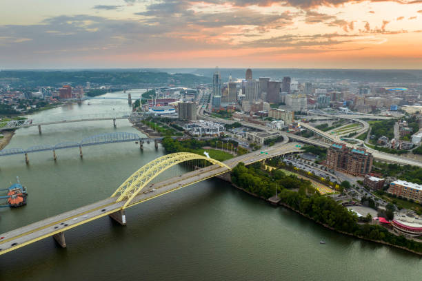 istock Highway traffic in Cincinnati, Ohio on Daniel Carter Beard Bridge with brightly illuminated high skyscraper buildings in downtown district. American city with business financial district at sunset 1986089801