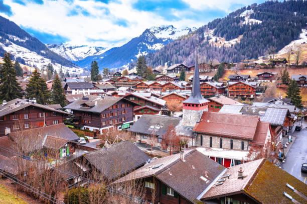 идиллическая деревня гштаад с видом на крыши, роскошное зимнее направление - bernese oberland gstaad winter snow стоковые фото и изображения
