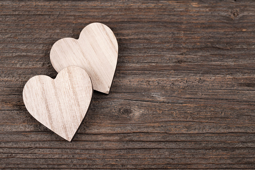 Wooden heart shaped empty box on wooden background.