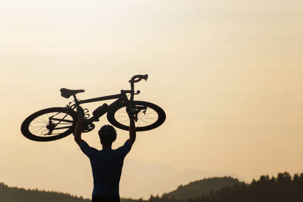 Cyclist on a racing bike outdoors in nature at sunset.