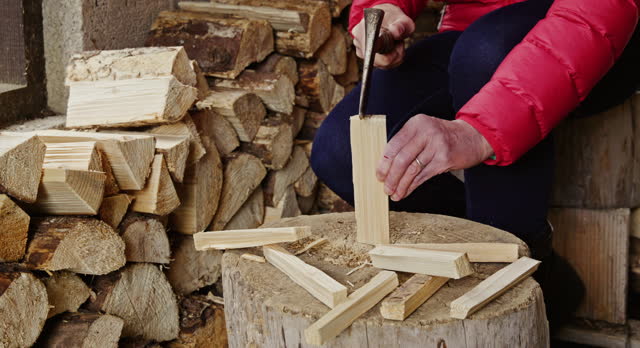 Woman splitting logs for kindling