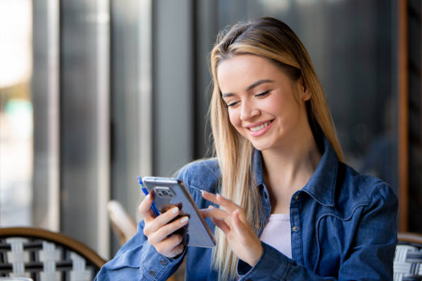 istock E-Learning Radiance: Student Smiles, Holds Pen, and Engages with Phone 1986182017
