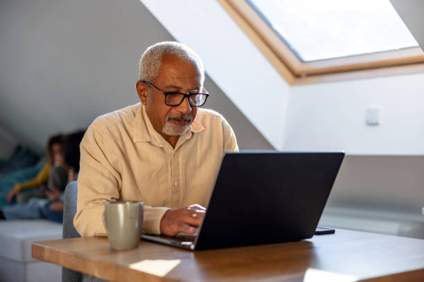 istock Senior Man Using Laptop at Home 1986195540