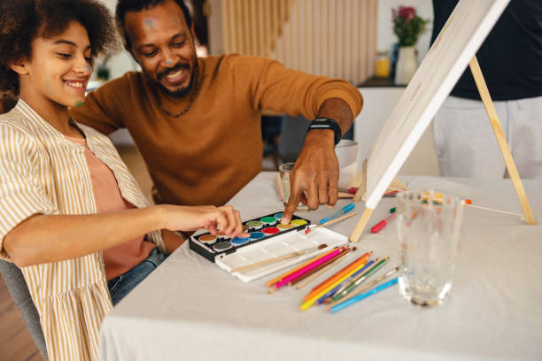 istock Joyful Hispanic Father and Daughter Enjoying Painting Activity 1986198162