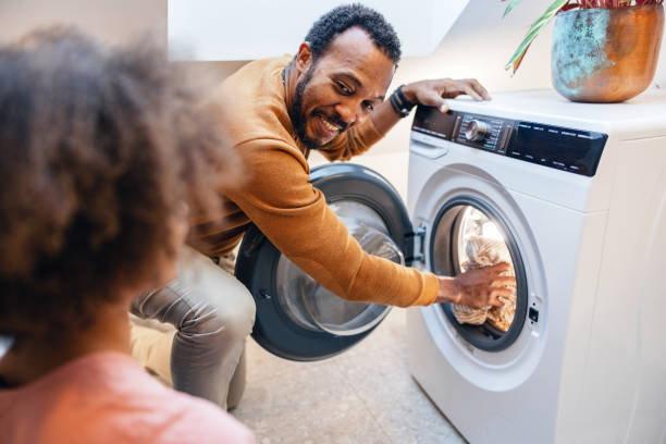 istock Happy Father Helping Child With Laundry 1986198876