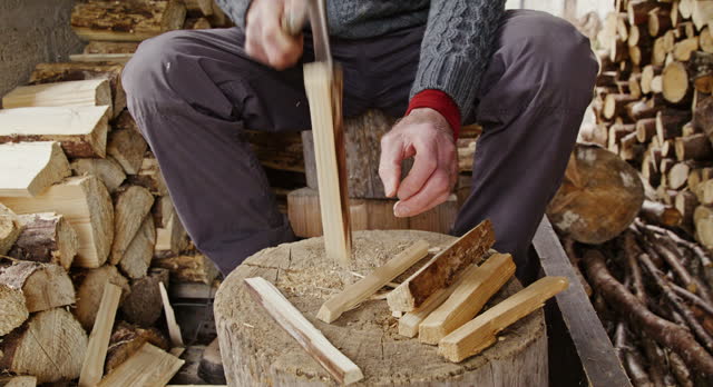 Senior man splitting logs for kindling