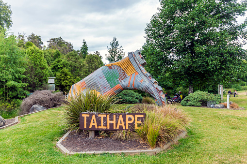 Taihape, New Zealand - December 22, 2023: This photograph captures a close-up view of the iconic landmark, a giant gumboot, which warmly welcomes visitors to the picturesque town of Taihape in New Zealand. The gumboot, a symbol of the town's unique identity and heritage, stands as a testament to Taihape's history as a thriving rural community. The photograph beautifully showcases the intricate details and vibrant colors of the landmark, inviting viewers to explore the charm and character of Taihape.