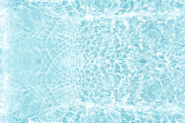 istock Bluewater waves on the surface ripples blurred. Defocus blurred transparent blue colored clear calm water surface texture with splash and bubbles. Water waves with shining pattern texture background. 1986401574