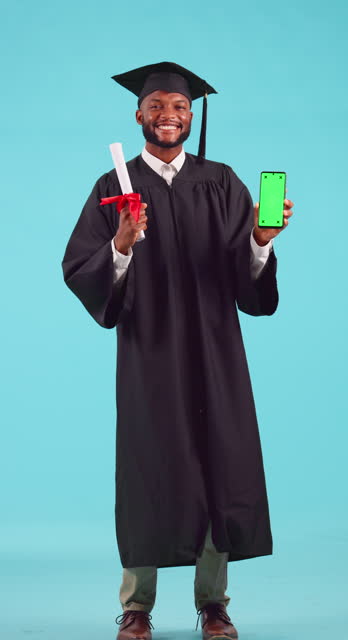 Education, graduation and green screen on a phone with a student black man in studio on a blue background. Portrait, certificate and chromakey on a mobile display with a male university graduate