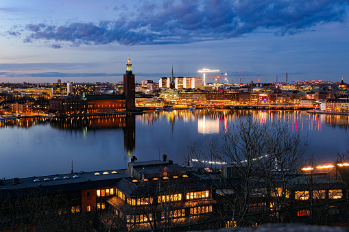 Skyline with crane houses and other office buildings in Colognes port with river rhine at dawn in blue hour.