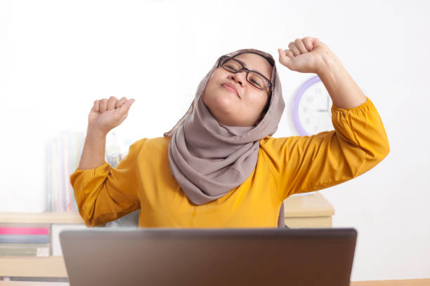istock Muslim Lady Stretch Her Arms and Back at the Office 1986471745