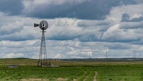 Small old wind turbine in a field against a cloudy sky in Tennessee, USA