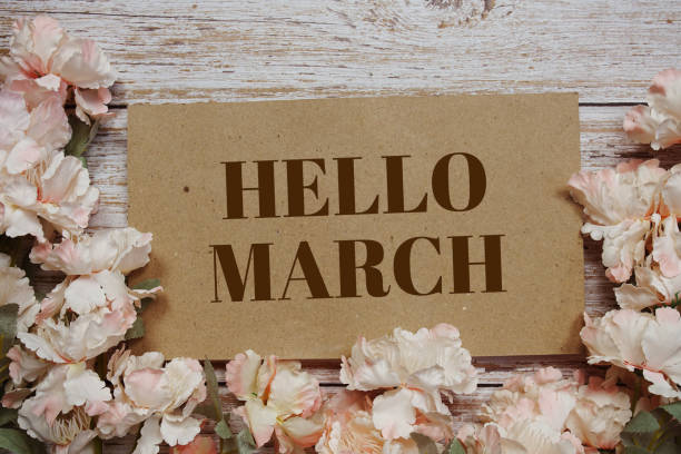 istock Hello March typography text with flowers frame on wooden background 1986487351