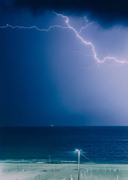 istock Lightning Strike Over the Ocean Captured at Night Near Beachfront 1986498362