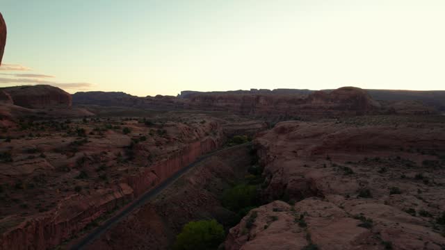 Drone shot flying in a canyon with train tracks in Moab, Utah
