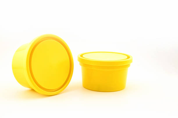 two yellow plastic containers with a lid for storing food, close-up side view on a white background