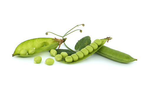 Open pea pod and round green peas inside in close up isolated on white background